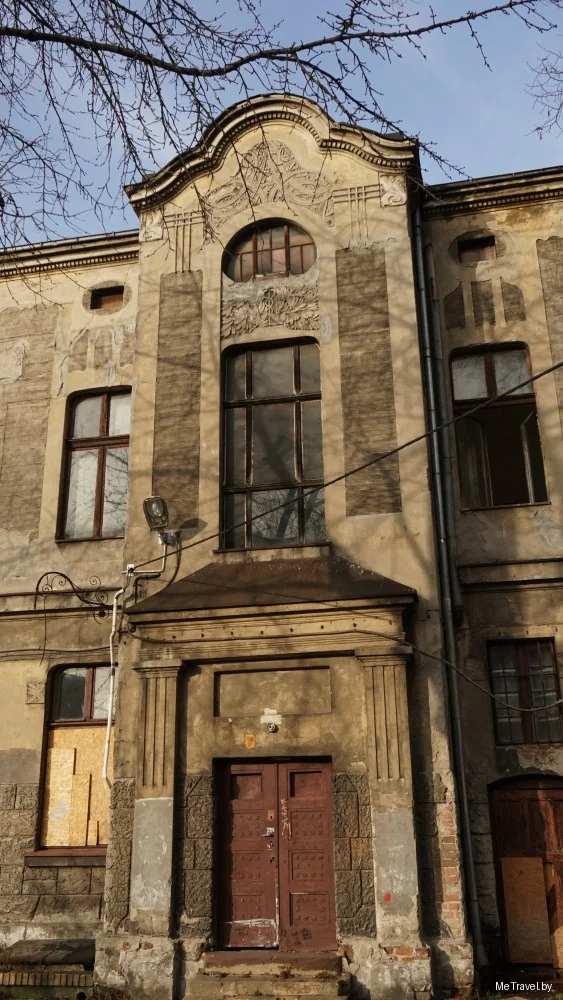 Обветшалый доходный дом в центре Лодзи: лепнина на фасаде, заколоченные окна первого этажа