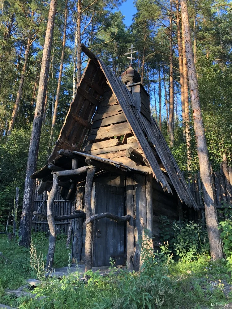 Бревенчатая часовня с крестом в сосновом лесу среди декораций